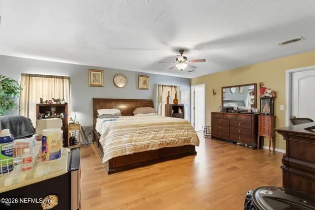 a spacious bedroom with a bed and a flat screen tv