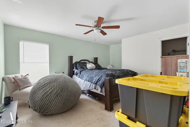 a bedroom with a bed and a ceiling fan