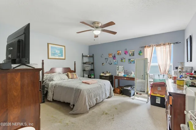 a bedroom with a bed and a flat tv screen on dresser