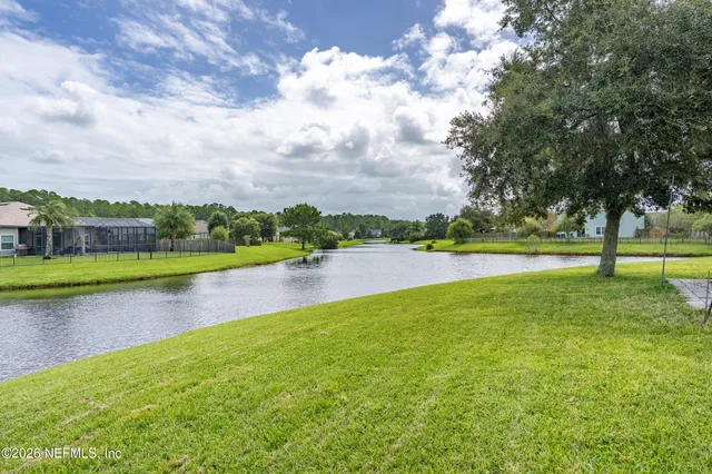 a view of a house with backyard and trees