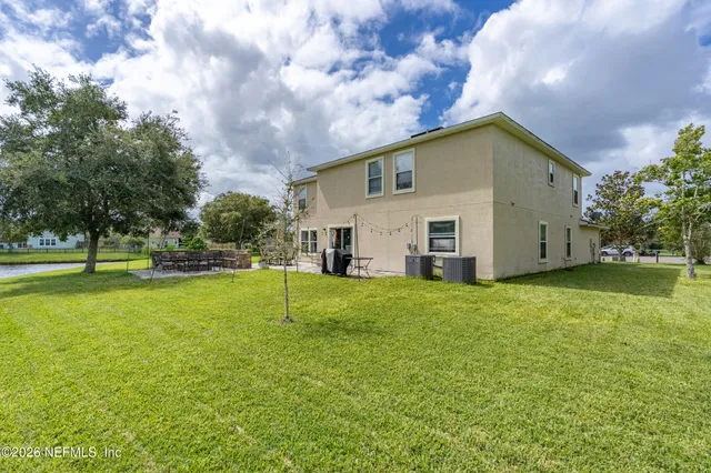 a view of a house with backyard and sitting area
