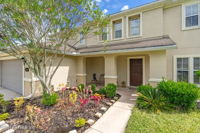 a living room with furniture a dining table and a potted plant