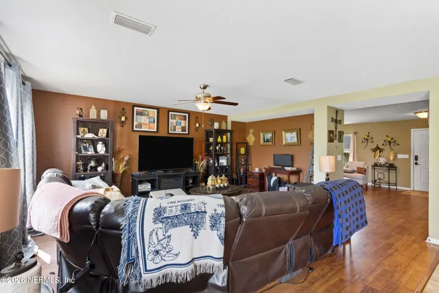 a living room with furniture kitchen view and a large window