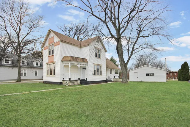 a front view of a house with a yard and trees
