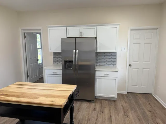 a kitchen with kitchen island white cabinets and stainless steel appliances