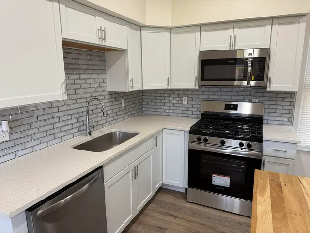 a kitchen with stainless steel appliances a stove a sink and a microwave