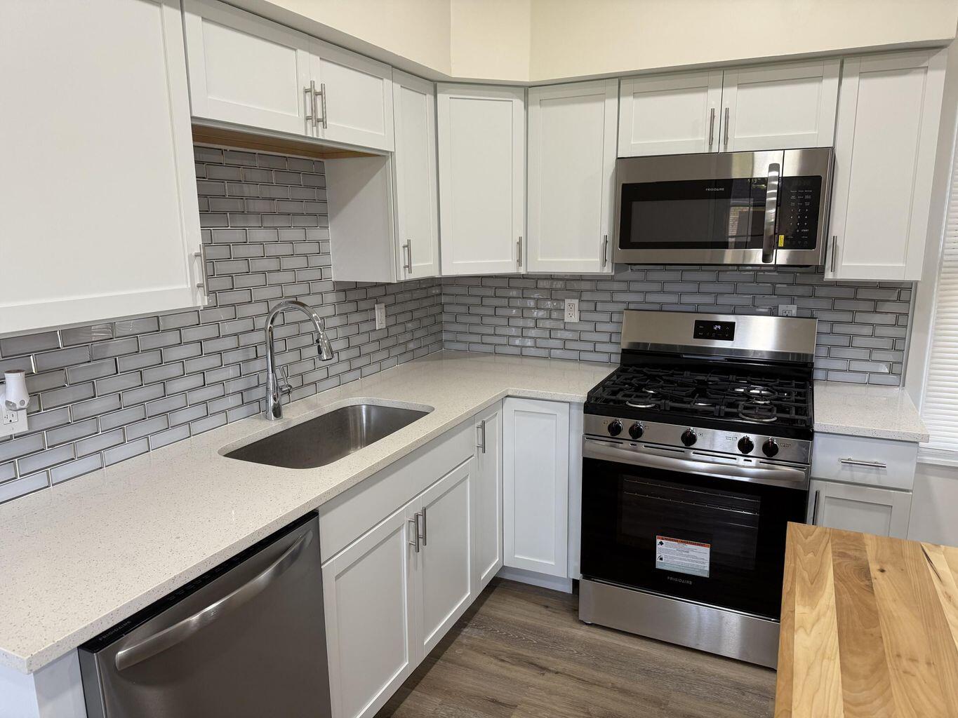 10450 West 93rd Avenue St. John, IN 46373 - Photo 19 of 22 a kitchen with stainless steel appliances a stove a sink and a microwave