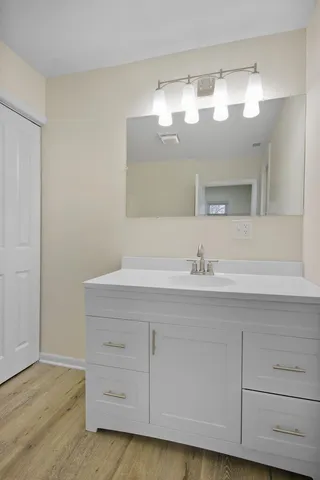 a bathroom with a sink vanity and mirror