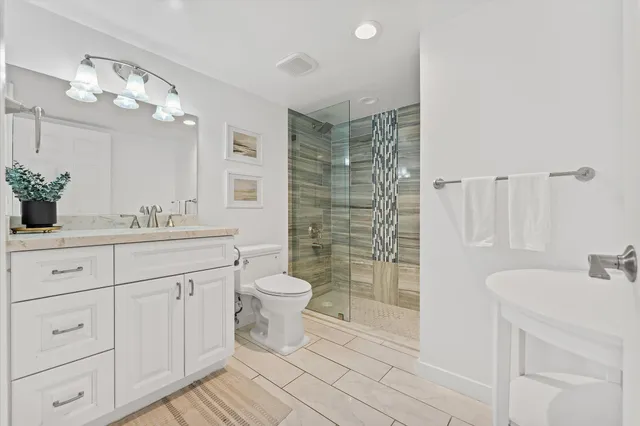 a bathroom with a sink a toilet and shower