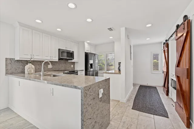 a kitchen with stainless steel appliances granite countertop a sink stove and microwave