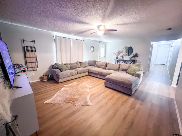 a living room with furniture and a wooden floor