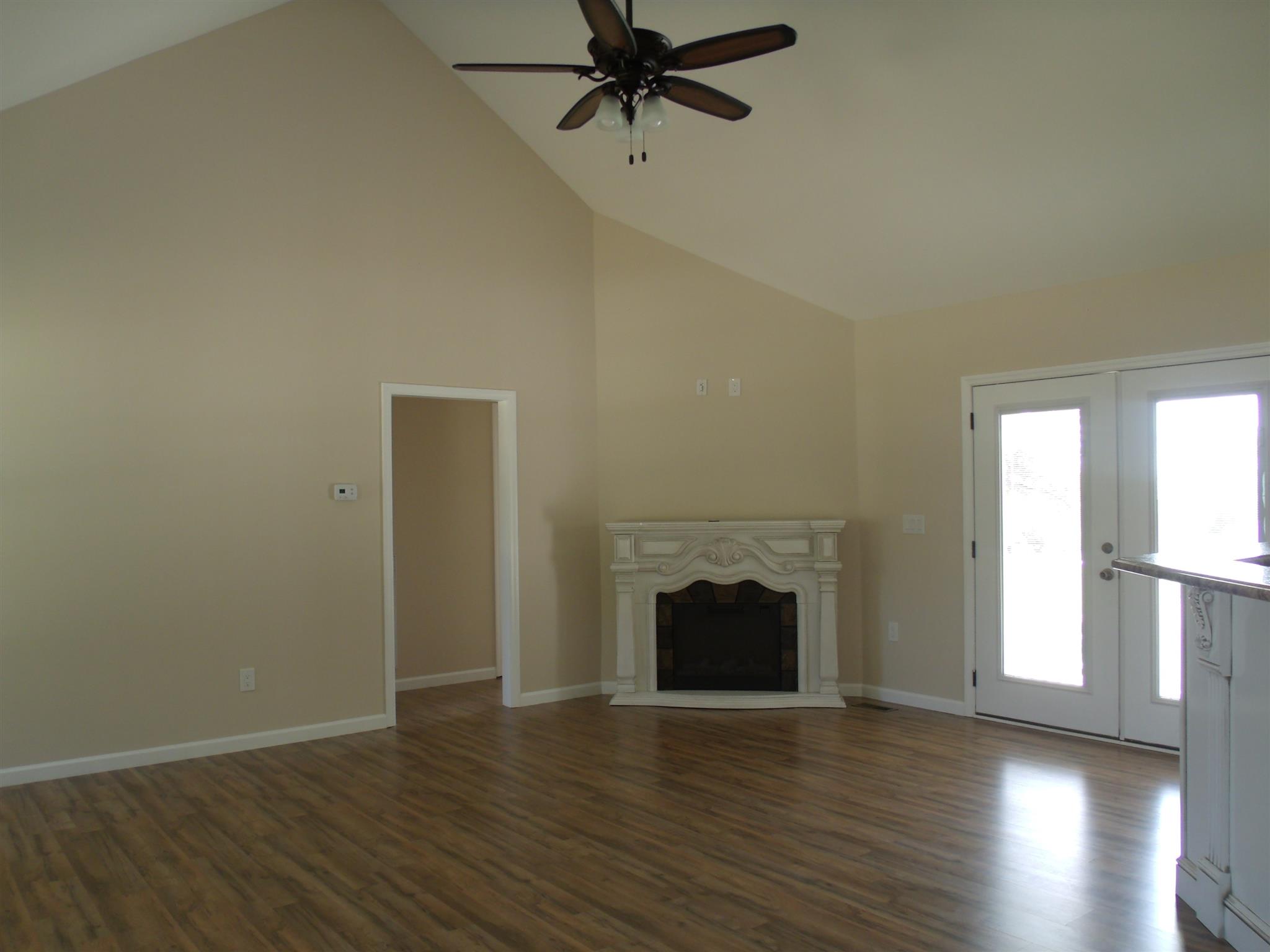 26 Liberty Road Winchester, TN 37398 - Photo 2 of 16 Living room has soaring ceiling, ceiling fan, gleaming laminate flooring, and an electric fireplace.