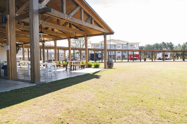 a view of swimming pool with lawn chairs and large trees