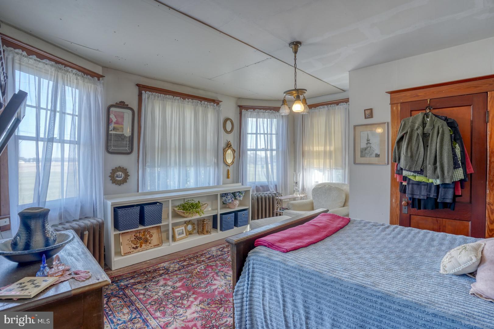 4096 Main Street Trappe, MD 21673 - Photo 45 of 70 a bedroom with a bed a dresser and wooden floor