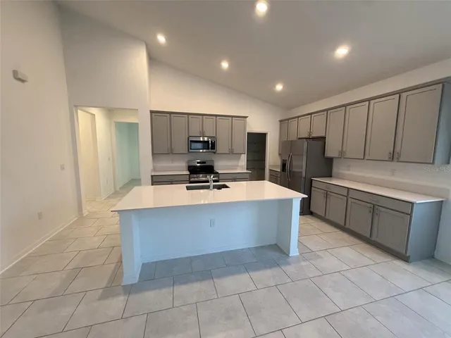 a large kitchen with kitchen island a sink stainless steel appliances and cabinets
