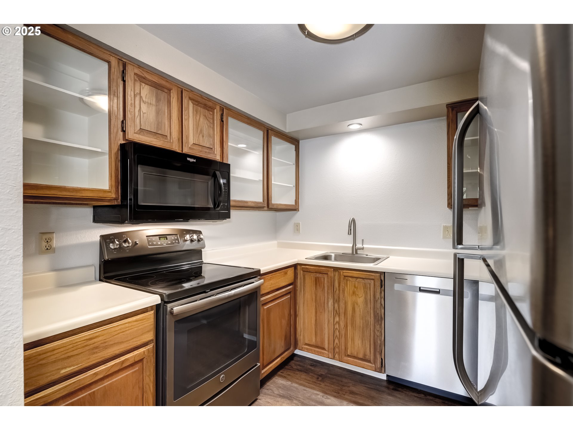 5557 Southwest Multnomah Boulevard Portland, OR 97219 - Photo 11 of 29 a kitchen with stainless steel appliances a stove microwave and sink