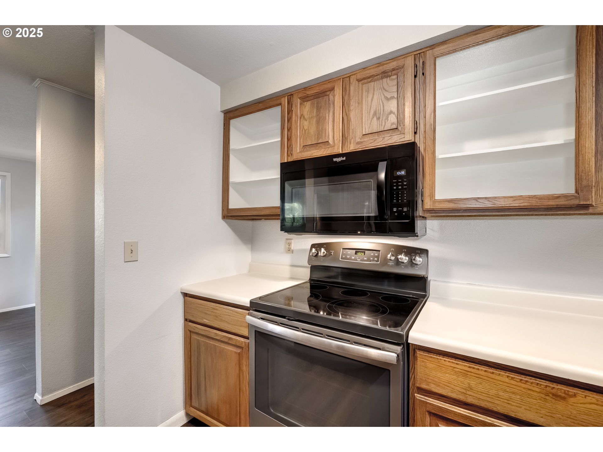 5557 Southwest Multnomah Boulevard Portland, OR 97219 - Photo 14 of 29 a kitchen with stainless steel appliances a stove a microwave and white cabinets