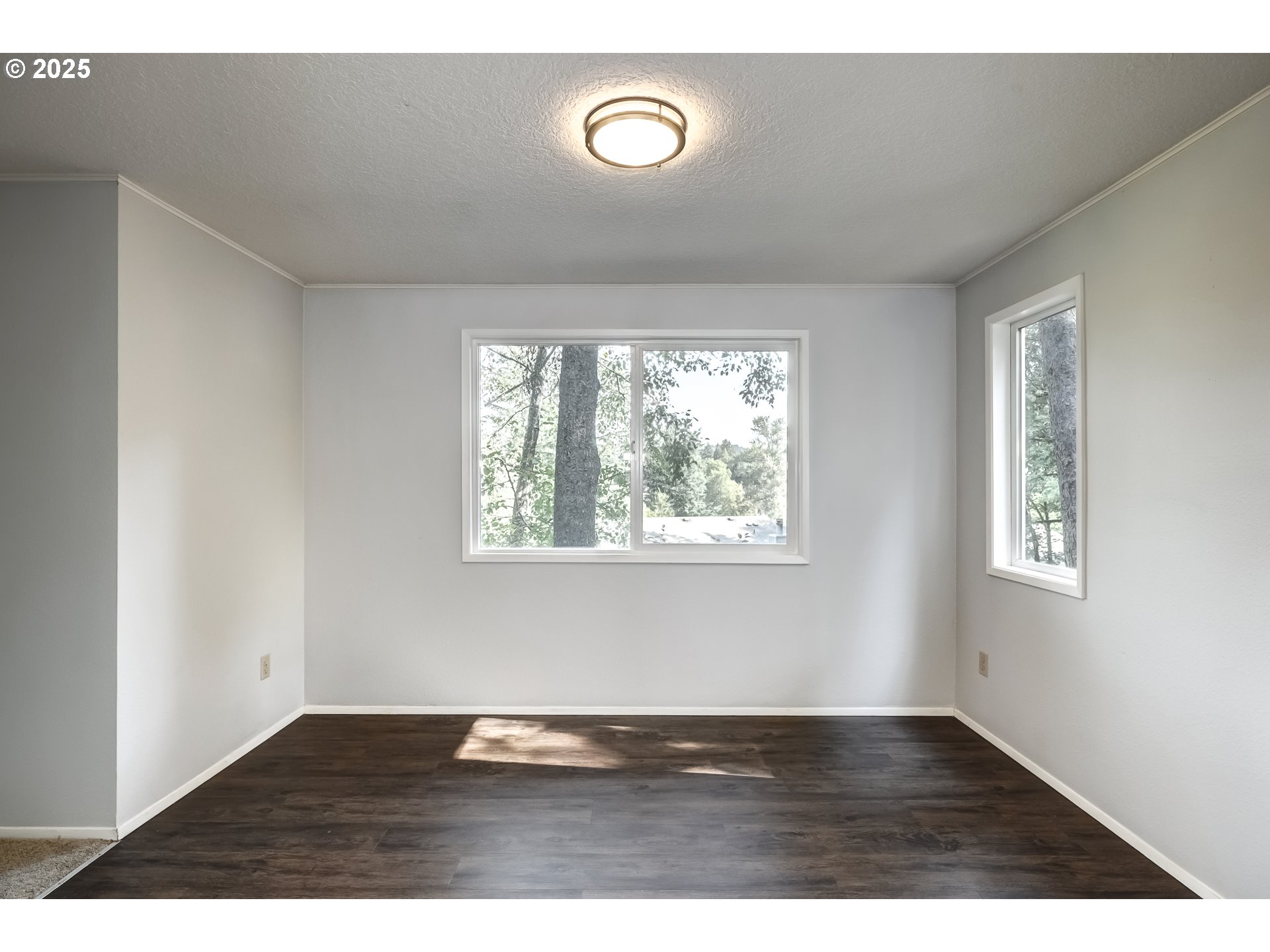 5557 Southwest Multnomah Boulevard Portland, OR 97219 - Photo 9 of 29 a view of an empty room with wooden floor and a window