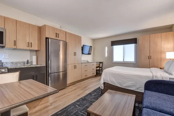 a bedroom with a bed and a refrigerator