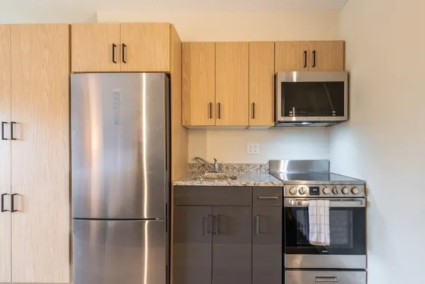 a kitchen with stainless steel appliances granite countertop a refrigerator and a stove top oven