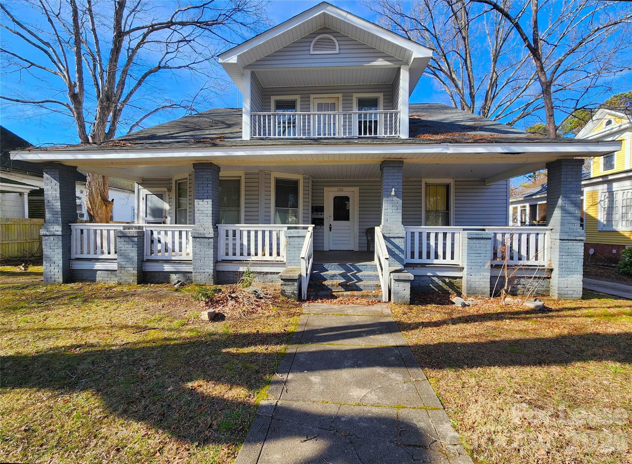 a view of a building with large windows and a small yard