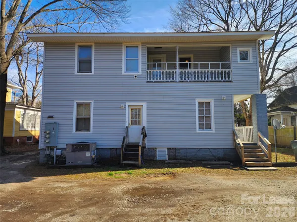a view of a house with a yard and a tree