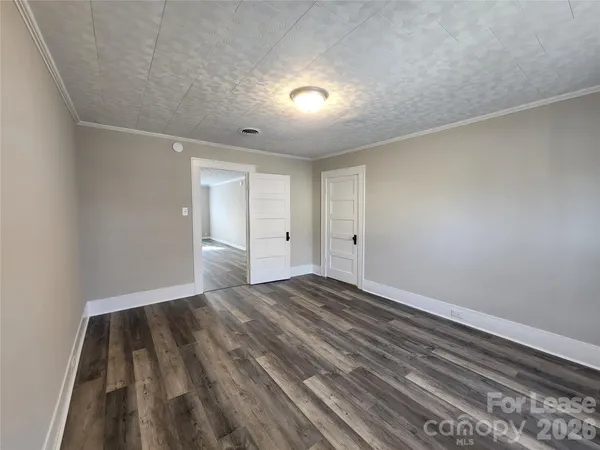 a view of empty room with wooden floor