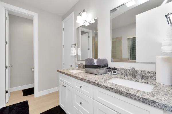 a bathroom with a granite countertop double vanity sink and a mirror