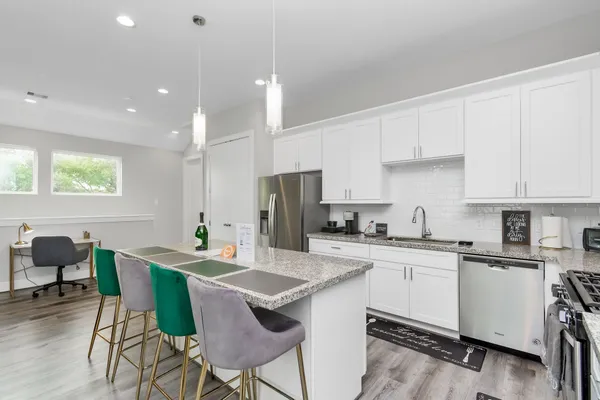 a kitchen with a dining table chairs sink and cabinets