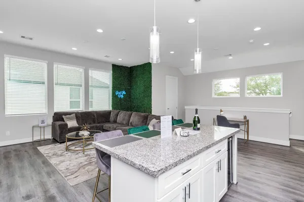 a kitchen with granite countertop kitchen island stainless steel appliances a sink and living room