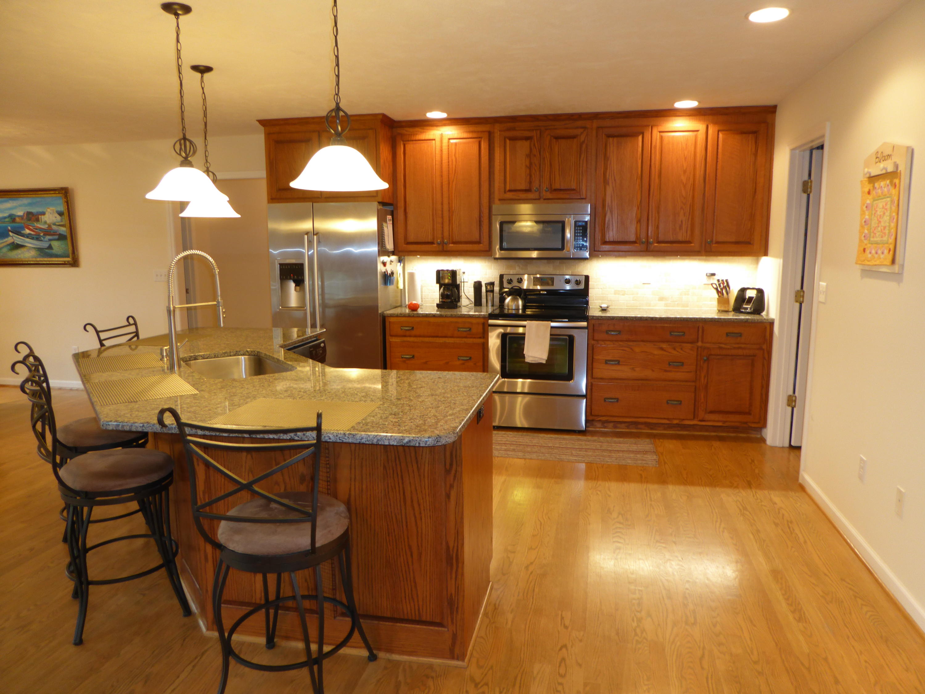 7740 Edwardsville Road Hardy, VA 24101 - Photo 9 of 92 a kitchen with stainless steel appliances granite countertop a kitchen island a stove a dining table and chairs with wooden floor