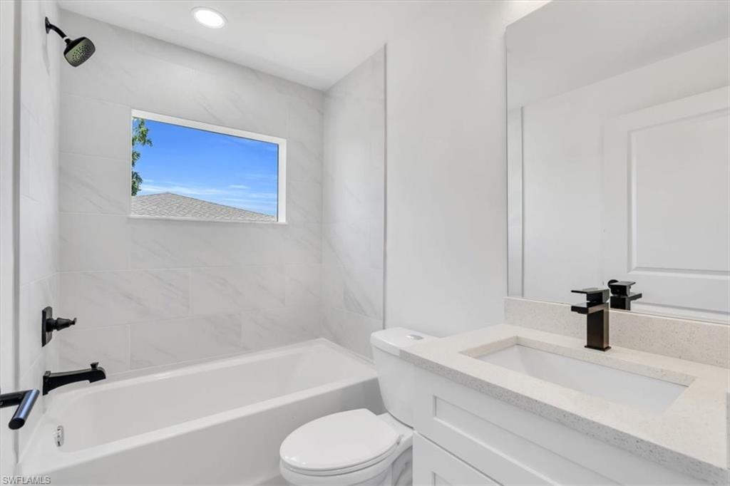 3317 7th Street Southwest Lehigh Acres, FL 33976 - Photo 20 of 23 a bathroom with a sink a toilet and a bathtub