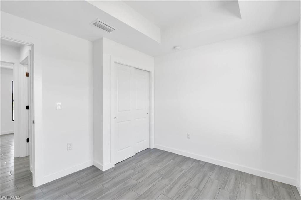3317 7th Street Southwest Lehigh Acres, FL 33976 - Photo 21 of 23 a view of an empty room with wooden floor