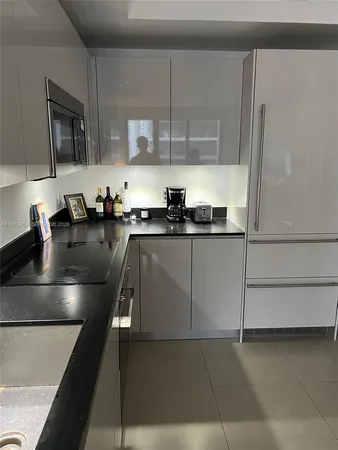 a kitchen with kitchen island granite countertop a sink and refrigerator