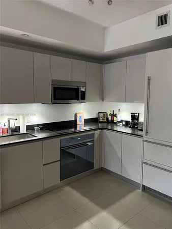 a kitchen with cabinets stainless steel appliances and a sink