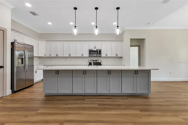 a view of kitchen with stainless steel appliances granite countertop cabinets and wooden floor