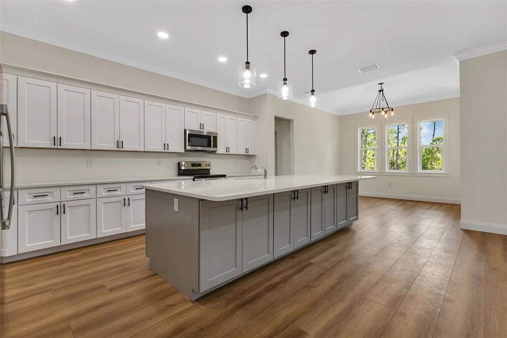 2444 Jacobs Street Port Charlotte, FL 33953 - Photo 13 of 52 a kitchen with stainless steel appliances granite countertop a stove a sink dishwasher a refrigerator and a dining table with wooden floor