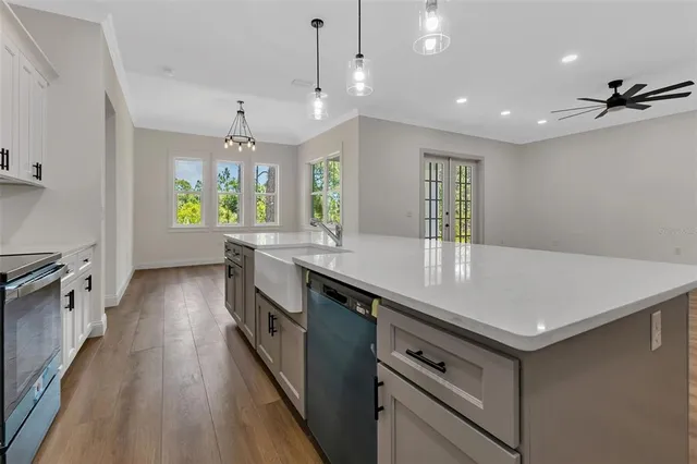 a kitchen with granite countertop a stove two sinks a refrigerator a stove a dining table and chairs