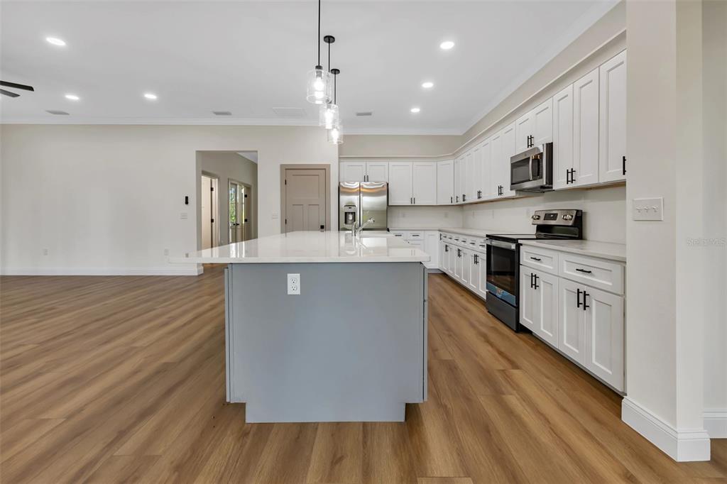 2444 Jacobs Street Port Charlotte, FL 33953 - Photo 15 of 52 a large kitchen with stainless steel appliances granite countertop a lot of counter space and wooden floors