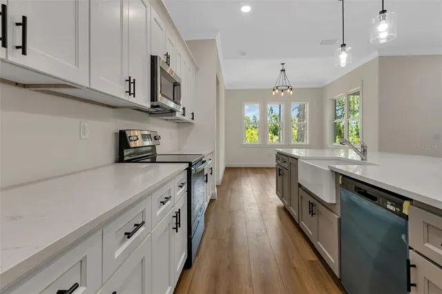 a kitchen with kitchen island granite countertop lots of counter top space and stainless steel appliances