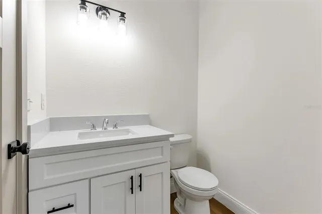 a bathroom with a granite countertop toilet and a sink