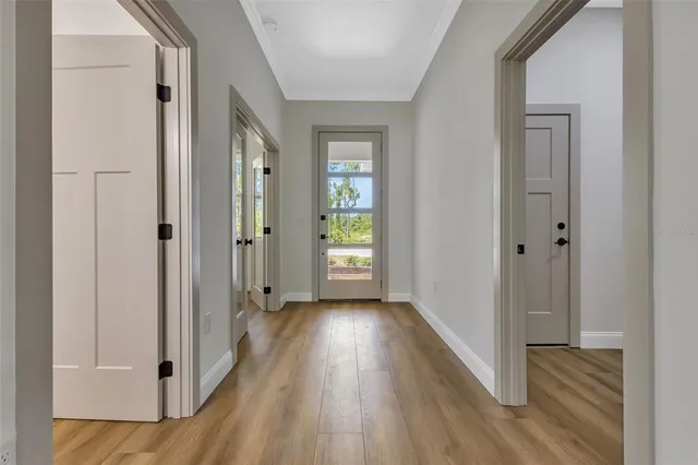 a view of a hallway with wooden floor and closet area
