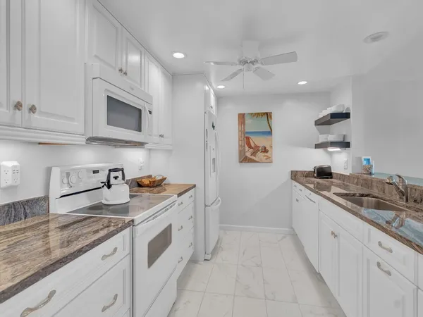 a kitchen with granite countertop cabinets stainless steel appliances and a sink