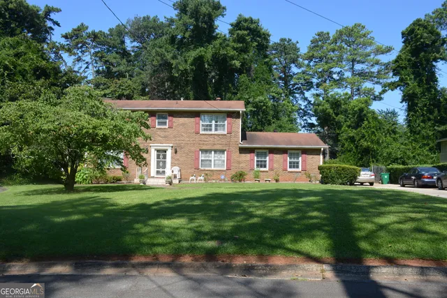 a view of a big house with a big yard and large trees