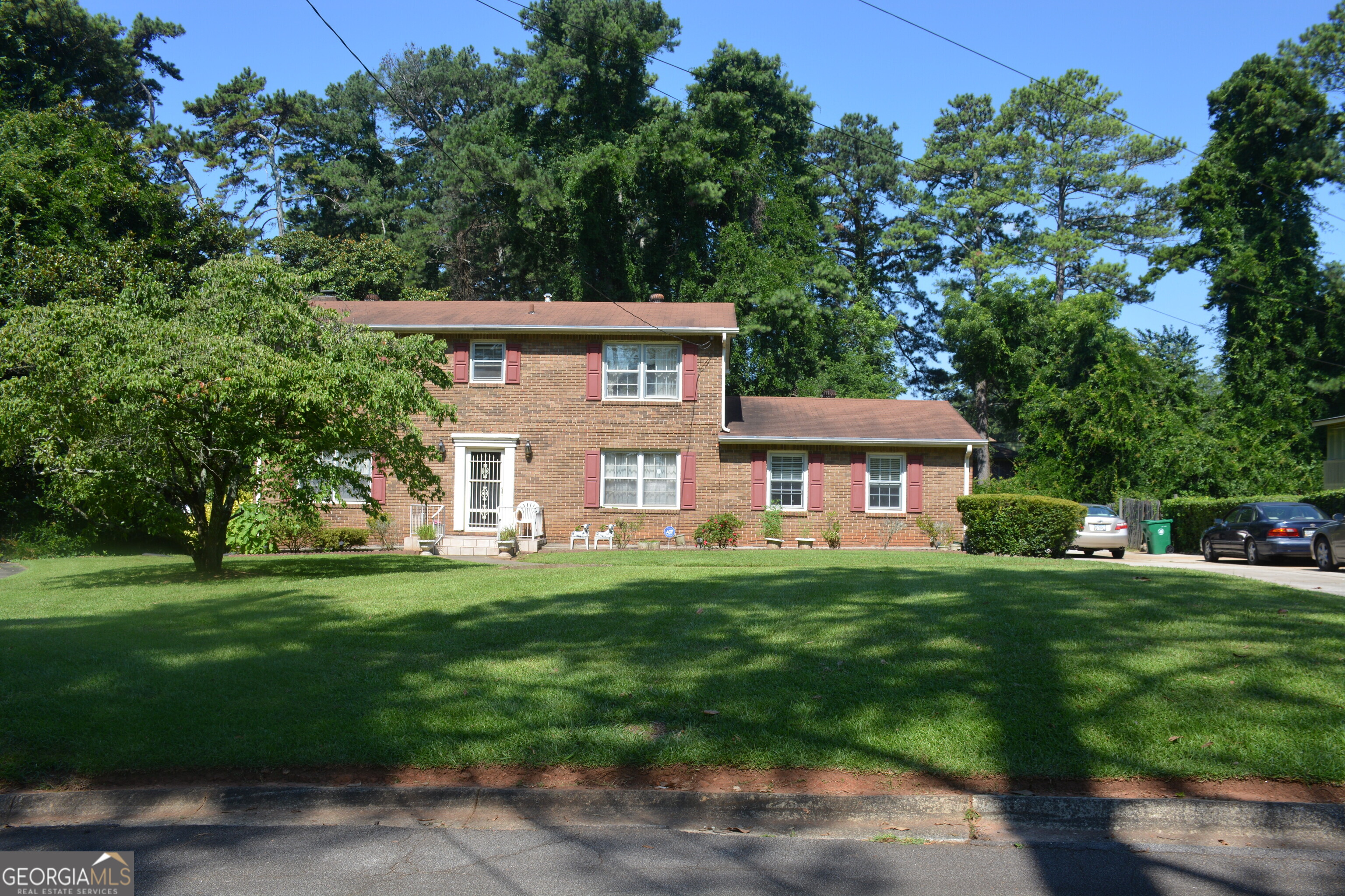 a view of a big house with a big yard and large trees