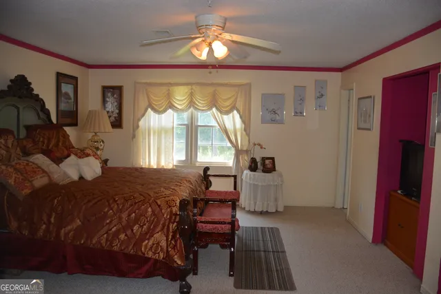 a bedroom with a bed and large windows