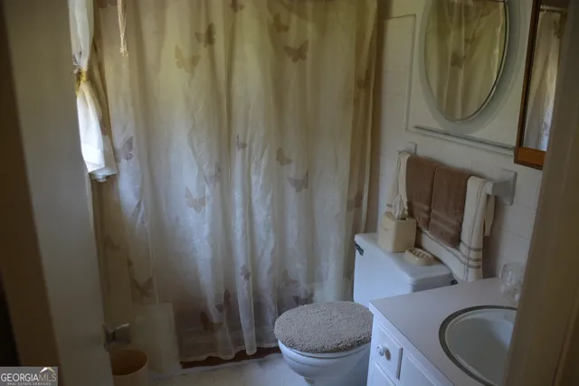 a white toilet sitting next to a shower curtain