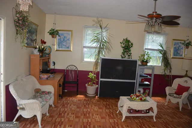 a living room with furniture a chandelier and a flat screen tv