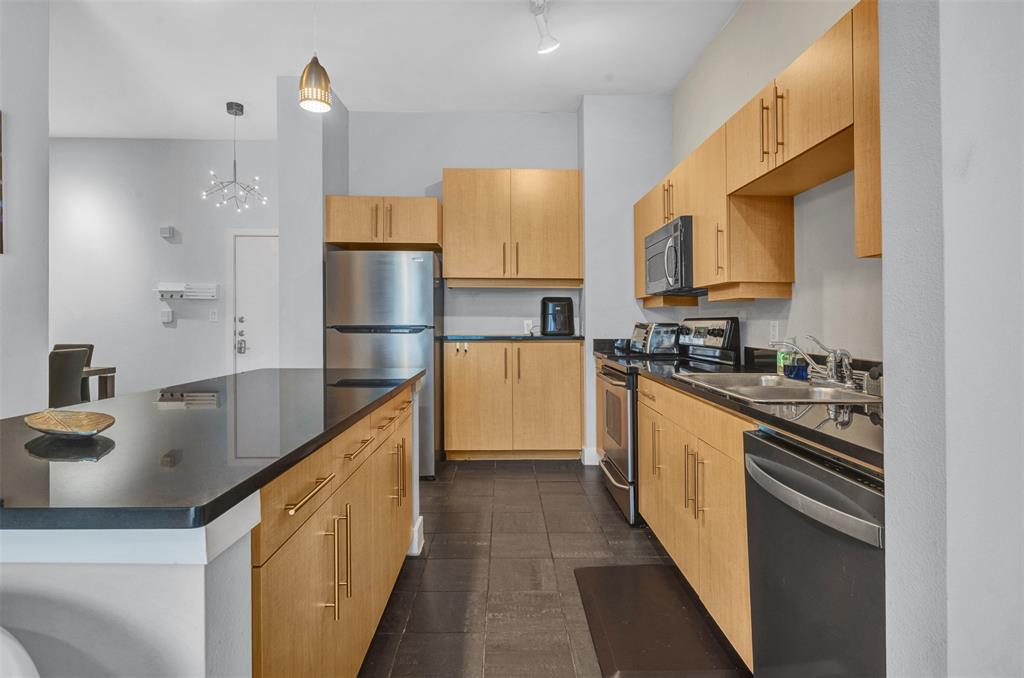 4414 Cedar Springs Road, Unit 314 Dallas, TX 75219 - Photo 9 of 26 a kitchen with stainless steel appliances granite countertop a sink a stove and a refrigerator