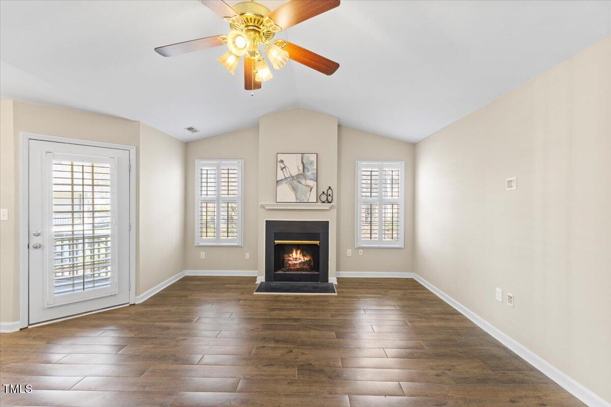 723 Renshaw Court Cary, NC 27518 - Photo 15 of 34 an empty room with windows fireplace and wooden floor
